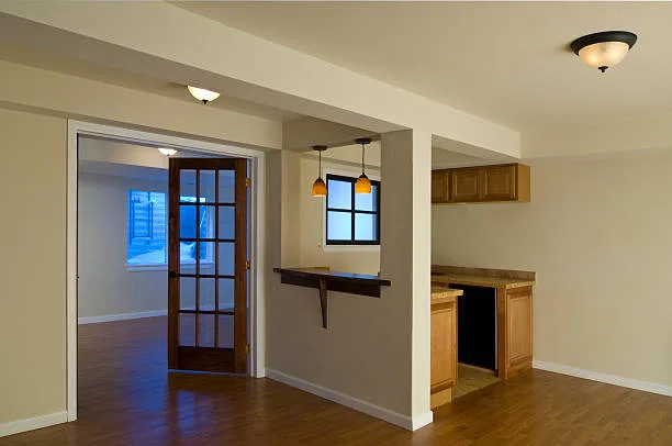 A basement finished with a wet bar, french doors, and copy-space