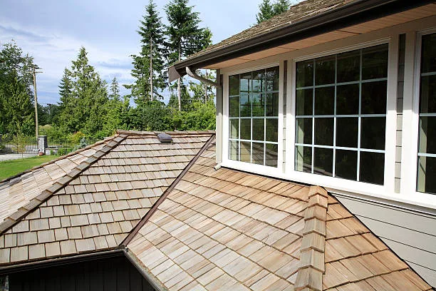 Close up looking down of New Cedar Shingle roof,gutters ,eaves and paned windows on a new home.