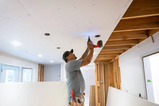 Drywall installers working in an old kitchen renovation