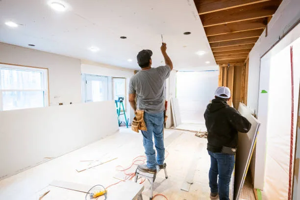 Drywall installers working in an old kitchen renovation