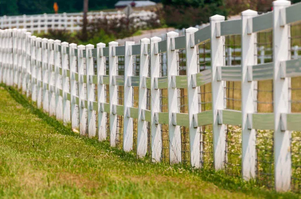 White fence separating fields in northern NJ.  Taken in sunlight in summer.