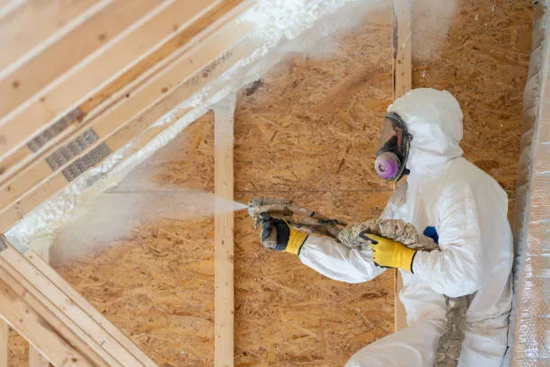 construction worker spraying house insulation