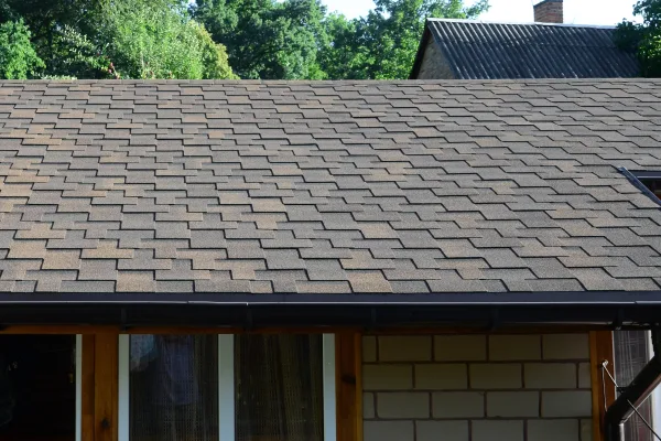 Modern roofing and decoration of chimneys. Flexible bitumen or slate shingles in rectangular shape in perspective.