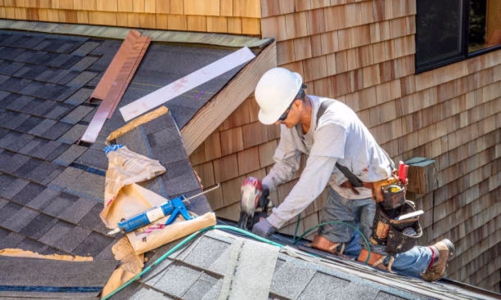 Installing new roof with  nail gun and shingles